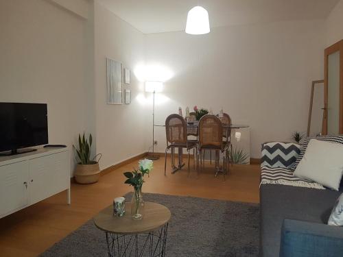 uma sala de estar com um sofá e uma mesa em Liberdadeflat4u em Braga