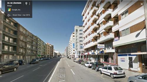 a city street with buildings and cars parked on the street at Liberdadeflat4u in Braga