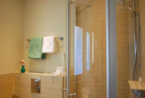 a shower with a glass door in a bathroom at Hotel am Südwäldchen in Westerland (Sylt)
