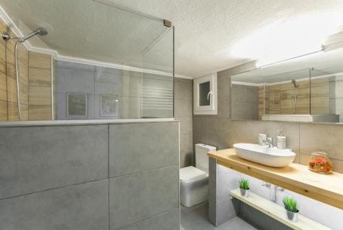 ein Bad mit einem Waschbecken und einer Glasdusche in der Unterkunft Style 'n' Comfort in Thessaloniki