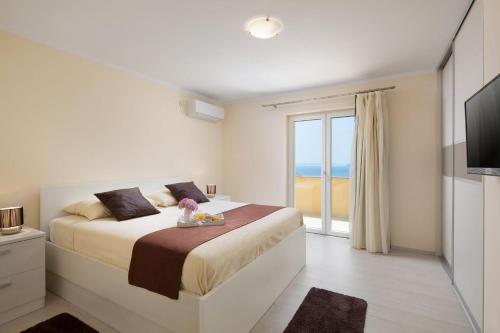 a bedroom with a bed with a view of the ocean at Villa Silvija in Poljane