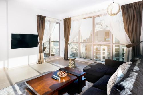 a living room with a couch and a table at One Bedroom Apartment Dubai Fountain & Old Town View by Auberge in Dubai