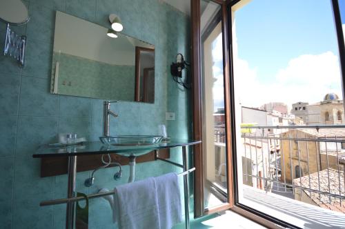 uma casa de banho com um lavatório e uma grande janela em Centro Sicilia Rooms-Suites & Terrace em Enna