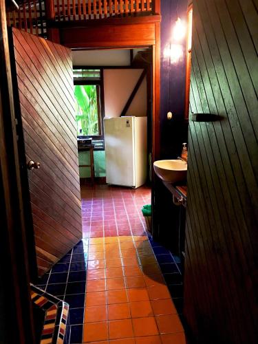 a kitchen with a refrigerator and a tile floor at Casita Rolando in Puerto Viejo