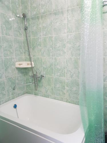 a bathroom with a shower and a white tub at Sport Hotel in Slavyanka