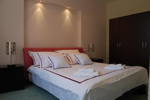 a bedroom with a large bed with towels on it at Vila Apolo in Belgrade