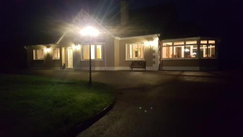 a house lit up at night with a street light at Large Luxury House in Ballyell