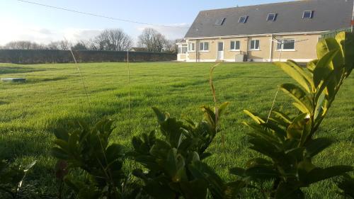 a field of grass with a house in the background at Large Luxury House in Ballyell