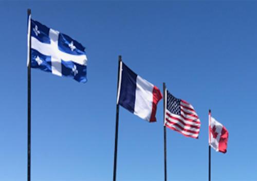 four flags of different countries flying in the sky at Motel La Marina in Matane