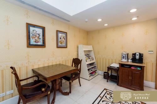 a dining room with a table and a refrigerator at Royal Seasons Hotel Taipei ‧ Nanjing W. in Taipei