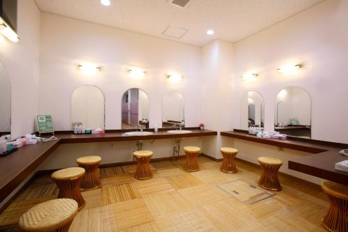 un salón con una fila de taburetes y espejos en Sakudaira Plaza 21, en Saku
