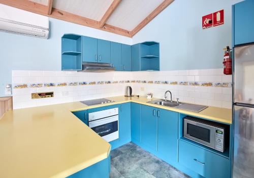 a kitchen with blue cabinets and a sink at NRMA Toowoon Bay Holiday Park in The Entrance