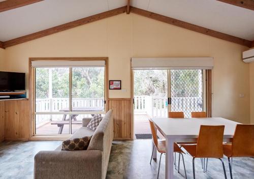 a living room with a couch and a table with chairs at NRMA Toowoon Bay Holiday Park in The Entrance