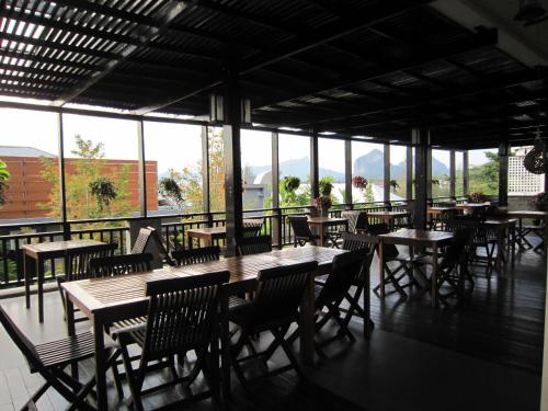 ein leeres Restaurant mit Tischen, Stühlen und Fenstern in der Unterkunft Royal Nakara Ao Nang in Ao Nang Beach