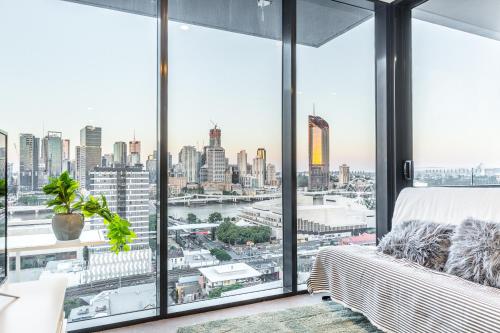 a bedroom with a large window with a view of the city at AirTrip Apartments on Merivale Street in Brisbane