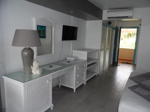 a room with a desk with a lamp and a mirror at studio "BLEU TURQUOISE" in Le Gosier