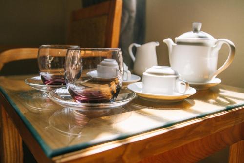 a wooden table with glasses and a tea set on it at Phương Phương 2 Hotel in Ha Tinh
