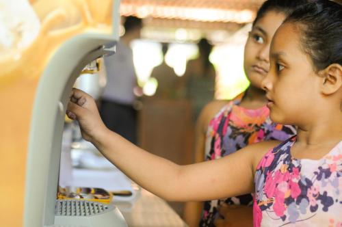 a young girl is looking at a machine at Green Garden Hotel in Kuta