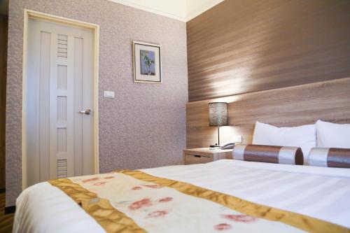 a hotel room with a bed and a door at Unique Hotel in Hualien City