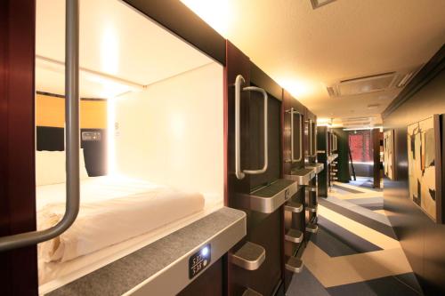 a small train room with a bed and mirrors at Ueno Station Hostel Oriental 1 Male Only in Tokyo