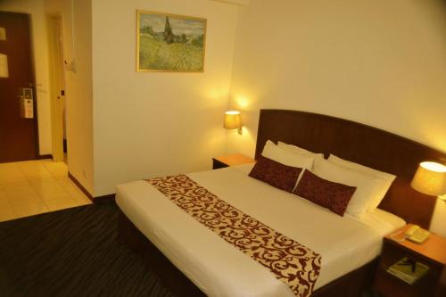 una camera d'albergo con un grande letto di Hotel Caliber a Kuala Lumpur