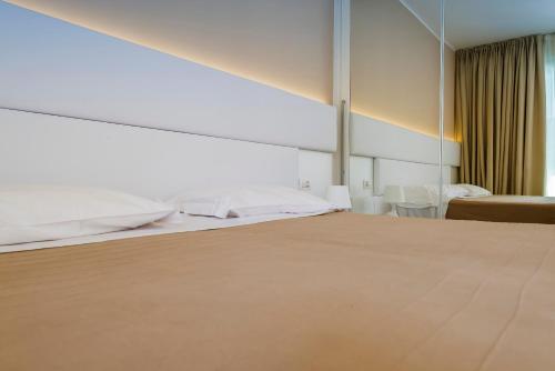 a hotel room with a bed and a mirror at Hotel Villa Katy in Bardolino