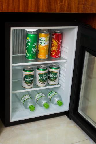 an open refrigerator filled with cans of soda at Catba Cannon Fort Hotel & Spa in Cat Ba