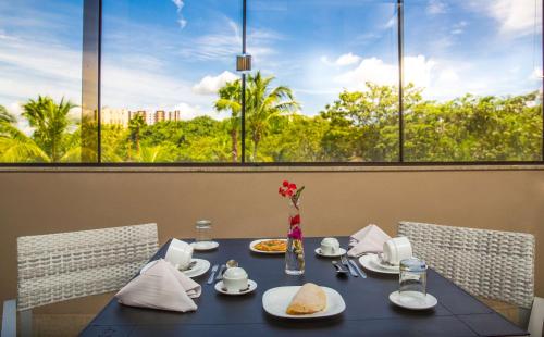 una mesa con comida y flores en un restaurante en Best Western Suites Le Jardin Caldas Novas, en Caldas Novas