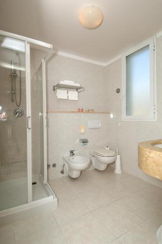 a bathroom with a shower and a toilet and a sink at Hotel Piccolo Lido in Bordighera