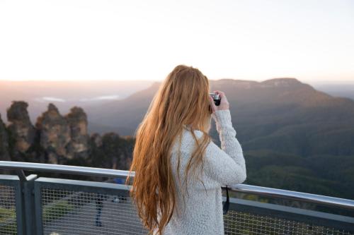 a woman taking a picture of the blue mountains at YHA Blue Mountains Katoomba in Katoomba