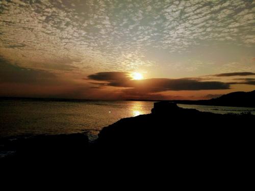 a sunset over a body of water with the sun setting at Summer Homestay in Kenting