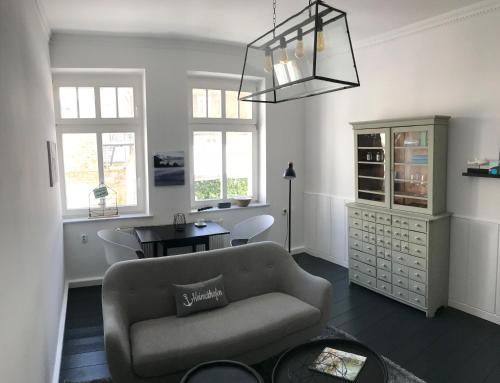 a living room with a couch and a table at Homelig Altstadt Ferienwohnungen Sassnitz Fewo 4 in Sassnitz