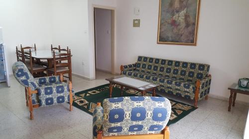 a living room with a couch and chairs and a table at Chariandry Court in Pissouri
