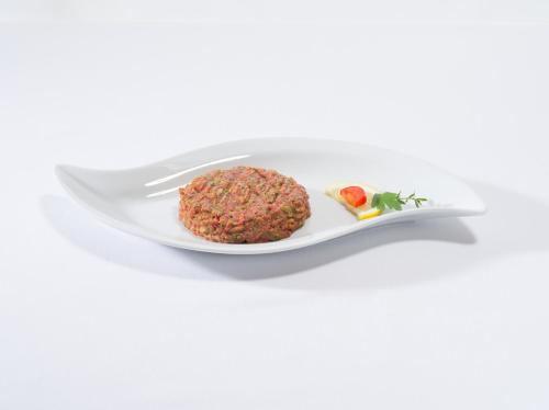 a white plate with a meatball and a knife and fork at Hotel La Perla in Sant' Antonino (S. Antonino)