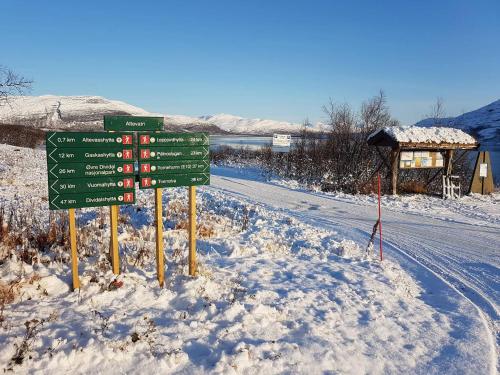 a street sign in the snow next to a road at Bardu Hotell in Setermoen
