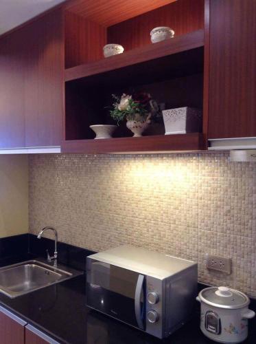 a kitchen with a sink and a microwave at Elizabeth 1829 @ Wind Residences in Tagaytay