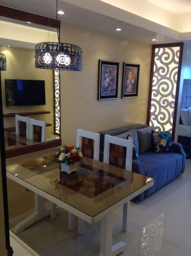 a living room with a table and a blue couch at Elizabeth 1829 @ Wind Residences in Tagaytay