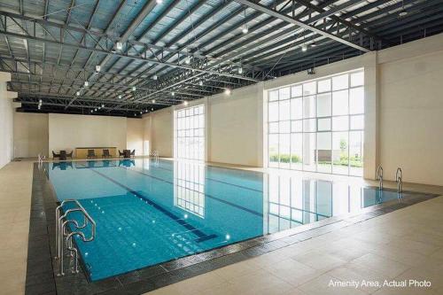 a large indoor swimming pool with blue water at Elizabeth 1829 @ Wind Residences in Tagaytay