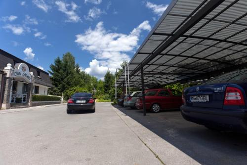 a parking lot with cars parked under a canopy at ApartHotel Vila Minka in Ljubljana