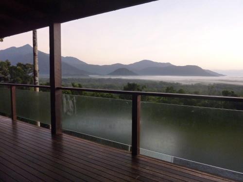 a balcony with a view of the water and mountains at Daintree Holiday Homes - La Vista in Cow Bay