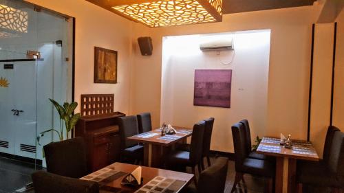 a restaurant with two tables and chairs in a room at The Saneer Jaipur in Jaipur