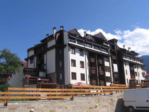 a black and white building with a van in front of it at Apart Hotel Comfort in Bansko