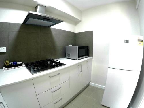 a kitchen with a stove and a microwave at City Waters in Perth