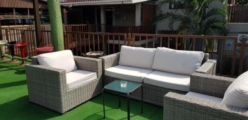 two wicker chairs and a table on a patio at GuestHouse 1109 in Maputo