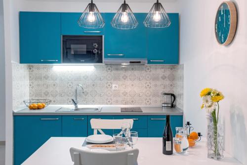 a kitchen with blue cabinets and a white counter top at Villa Kala Komiža in Komiža