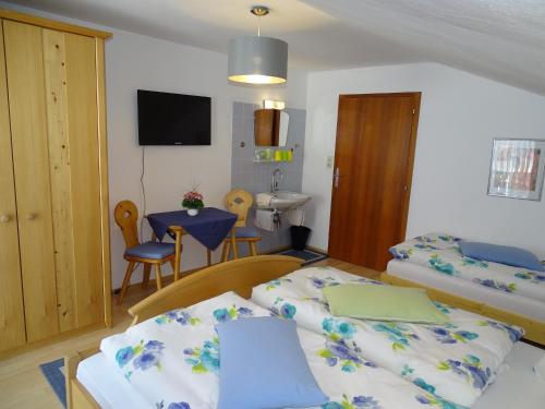 a hotel room with two beds and a table at Pension Bayrhammer in Faistenau
