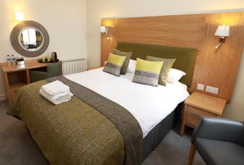 a bedroom with a large bed and a chair at The Famous Star Hotel Moffat in Moffat