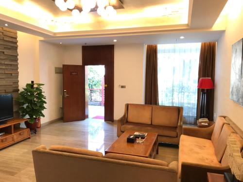 a living room with a couch and a table at Guangzhou Fangyuan Hotel - Free Shuttle Bus to Canton Fair Complex during 14th Oct to 3rd Nov in Guangzhou