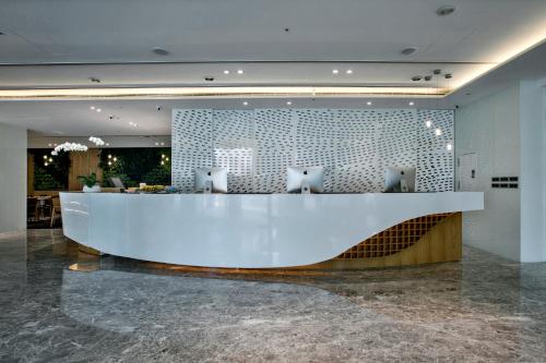 a lobby with a large white counter and chairs at The Carlton Taichung in Taichung
