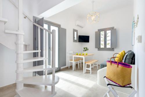 a white staircase in a living room with a table at White Harmony Suites in Megalokhori